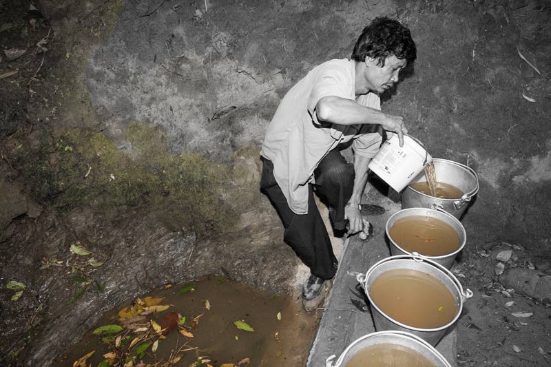 Human Right to Water in Nagaland - Filling buckets with water from a visibly unclean spring-fed drinking water source